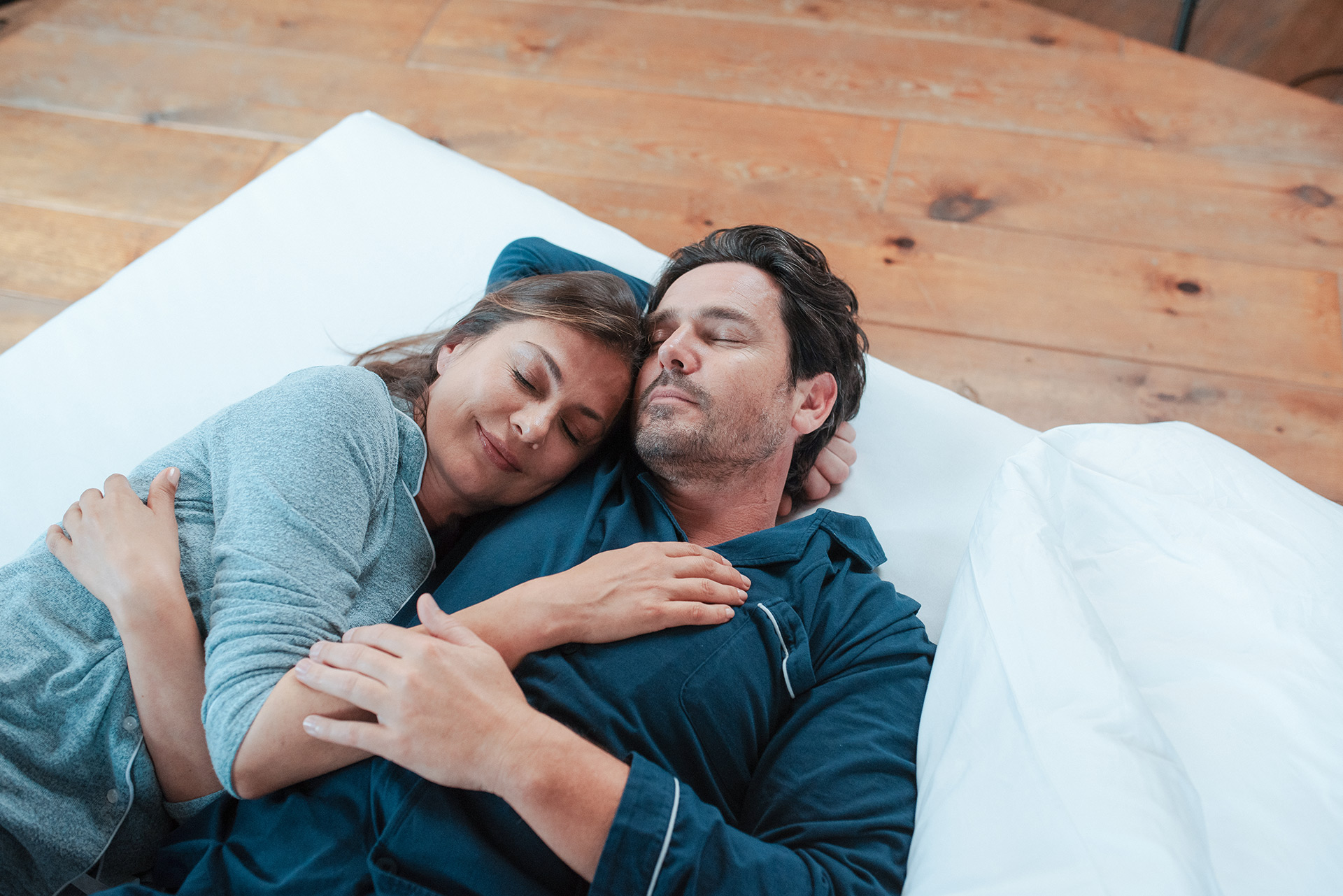 Ehepaar kuschelt gemütlich im Bett